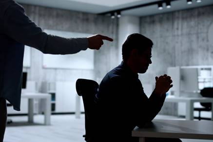 Man pointing to employee in the dark - Hostile Work Environment